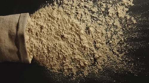 Spilled Flour From Burlap Sack on Dark Surface