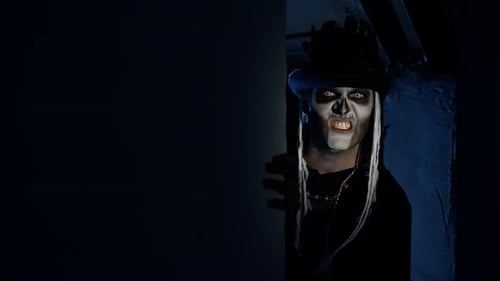 Sinister Man with Halloween Skeleton Makeup Appears From Dark Corner Shouting, Trying To Scare