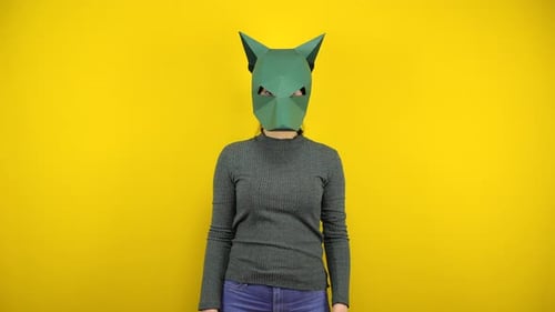 Woman Wearing Green Animal Mask Against Yellow Backdrop