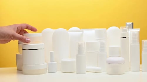 Hand Arranging White Skincare and Cosmetic Products
