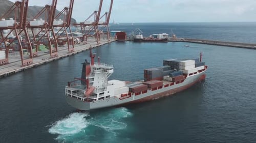 A Cargo Ship with Containers Enters the Port for Unloading.