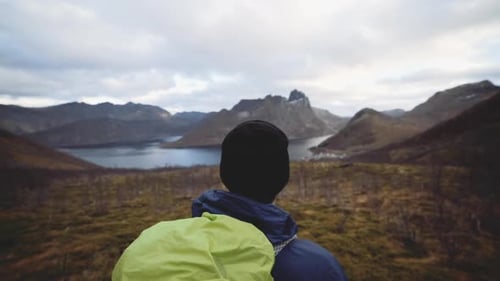 Hiker Looks at Mountain Landscape From Hilltop