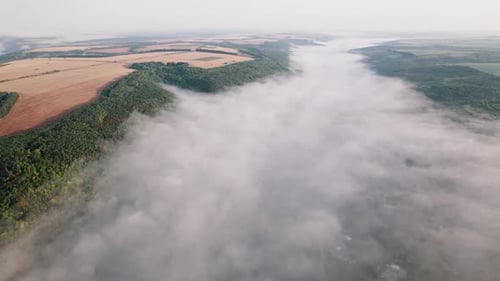 Aerial Drone View of Valley with Village Between Mountains During Misty Morning