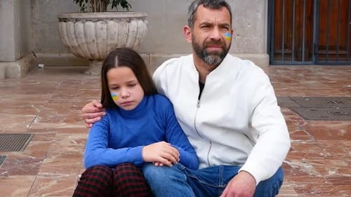 Man and Child Sitting Outside with Flag Makeup