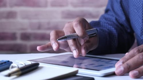 Man's Hand Working on Digital Tablet at Office Desk, Using Self Created Chart