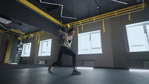 Sporty Woman Doing TRX Exercises in the Gym