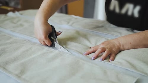 Woman Cutting Fabric With Scissors at Table