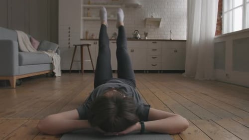 Woman Exercising Abs Lying on Floor at Home