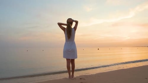 Young Happy Woman Standing on Sandy Beach By Seaside Enjoying Warm Tropical Evening