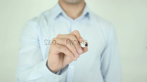 Man Writes SEO Package on Glass Surface