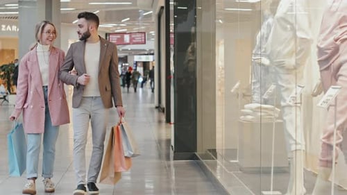 Stylish Young Couple Walking Along Big Shopping Centre