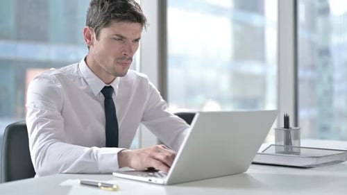 Businessman Working at Computer Massages Temples Suffering Headache