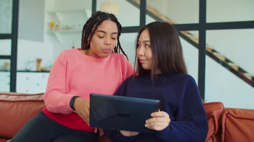 Friends Relaxing, Using Tablet Device on Couch