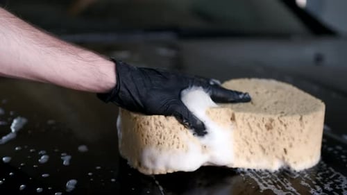 Man Washing His Car in a Garage