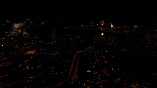 Fireworks Exploding Above Urban Cityscape at Night