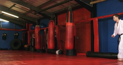 Man Practicing Karate Kicks in Gym