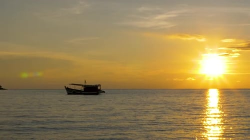 Fishing Boat Floating on Ocean at Sunset