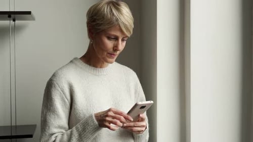 Woman Using Smartphone Indoors in Bright Room