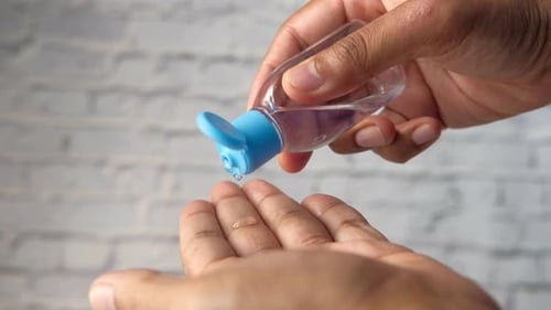 Close Up of Young Man Hand Using Sanitizer Gel for Preventing Virus