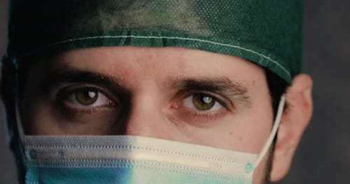 Yeux d'un médecin de sexe masculin souriant sous le masque