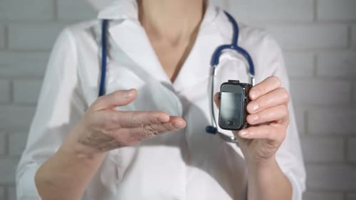 Medical Professional Holds Pulse Oximeter in Office