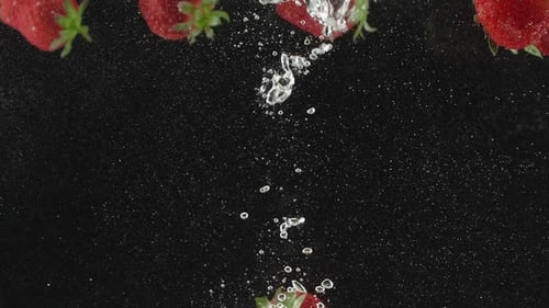 Strawberry Beautiful Falling Into Water in Slow Motion on Black Background
