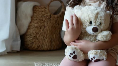 Child Hugging Teddy Bear in Cozy Setting
