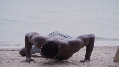 African American Man Doing Pushups While Exercising at the Beach