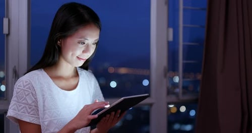 Woman use of tablet computer at night