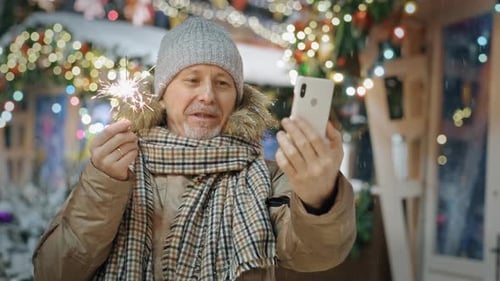 Man with Sparkler and Cell Phone During Winter