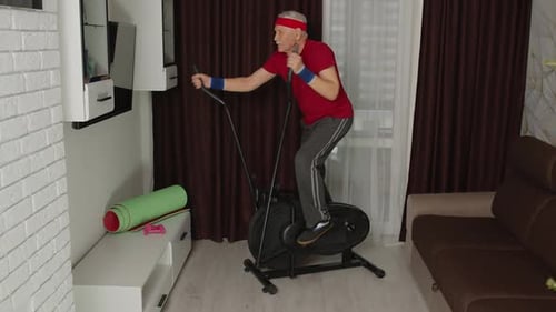 Senior Man Exercising on Stationary Bike at Home