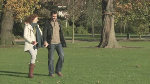 Couple walking through park holding hands