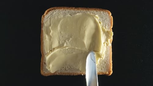 Buttering Bread Slice with Knife, Close Up