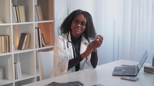 Friendly Female Doctor Explaining at Desk