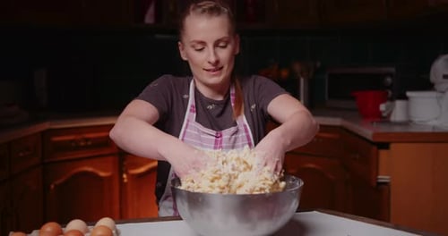 Woman Mixing Dough by Hand in Kitchen