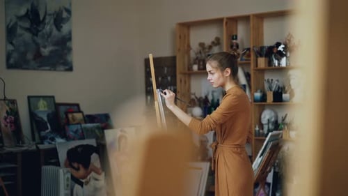 Young Lady Is Focused on Painting Working in Modern Studio Enjoying Creative Hobby