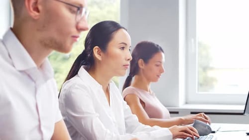 Diverse team of young professionals is working in the phone support office.