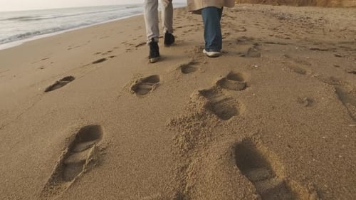 Happy Couple Walking on the Wild Beach on Cloudy Sunrise or Sunset