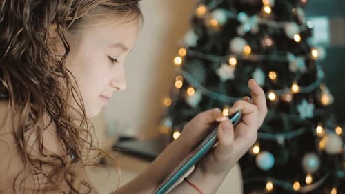 Child Using Tablet Near Christmas Tree