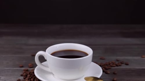 Coffee Cup and Coffee Beans on Wooden Table