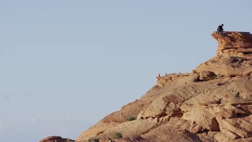 Lone Man Walking on Sandstone Plateau