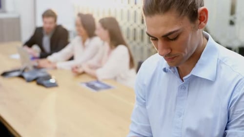 Smiling Man Uses Tablet in Modern Office Setting