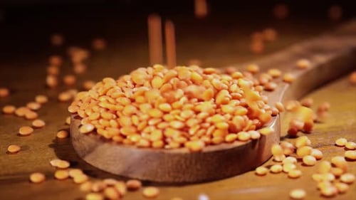 Red Lentils Pouring into a Wooden Spoon