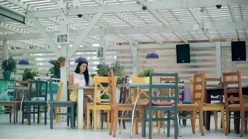 Young Woman Working on Laptop in Cafe and Drinking Coffe