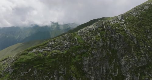 Luftaufnahme von Wandertouristen, die hinter den Steinen erscheinen und den Berg hinuntergehen