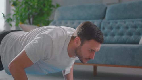 Young Man Doing Pushups at Home on Blue Mat