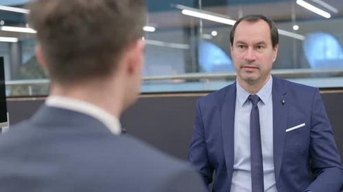 Rear View of Businessman Talking to Colleague in Office