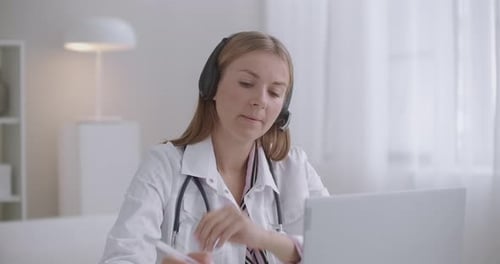 Woman Doctor Telehealth Consultation Using Headset and Laptop