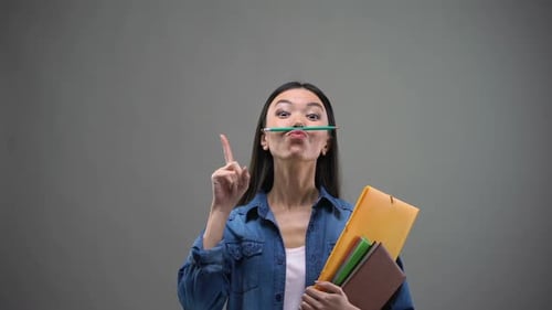 Woman Poses with Pencil and School Supplies