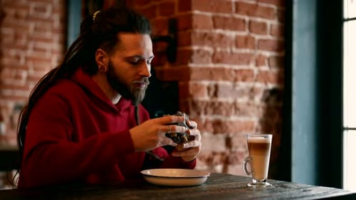 Young Man is Eating Hamburger in Cafe Enjoying Fast Food Fresh Meat Burger